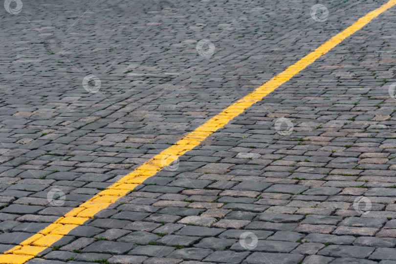 Скачать Диагональная желтая линия разметки на каменном тротуаре (фон, абстракция) фотосток Ozero