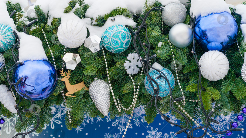 Скачать Крупный план новогодних игрушек, шаров, шишек, снежинок, развешанных на засыпанной снегом рождественской елке фотосток Ozero