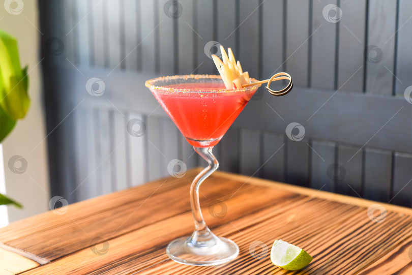 Скачать Алкогольный коктейль Cosmopolitan на деревянном столе на фоне темной стены с пространством для копирования фотосток Ozero