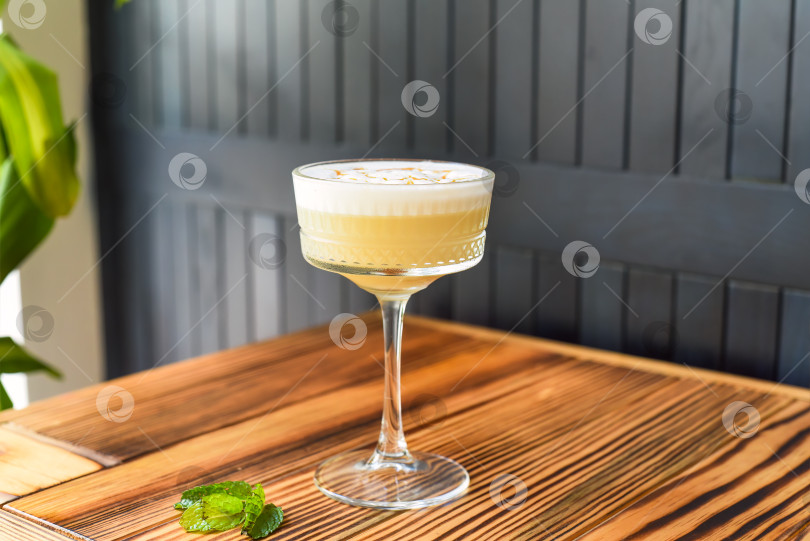 Скачать Алкогольный коктейль Whisky sour на деревянном столе на фоне темной стены с пространством для копирования фотосток Ozero