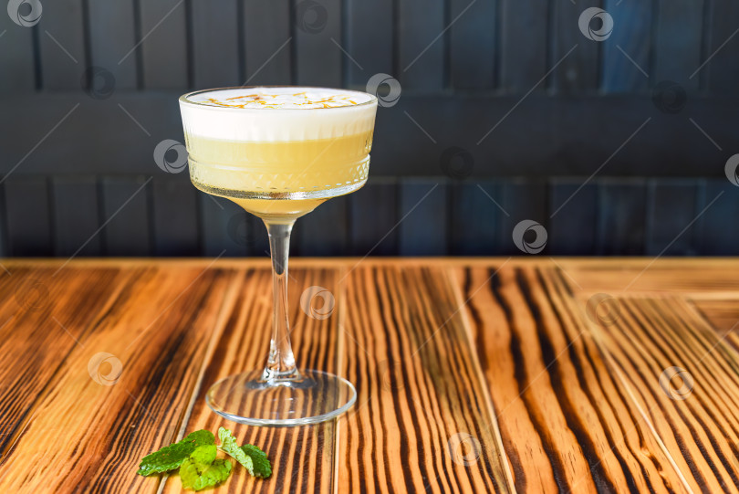 Скачать Алкогольный коктейль Whisky sour на деревянном столе на фоне темной стены с пространством для копирования фотосток Ozero