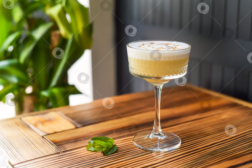 Скачать Алкогольный коктейль Whisky sour на деревянном столе на фоне темной стены с пространством для копирования фотосток Ozero