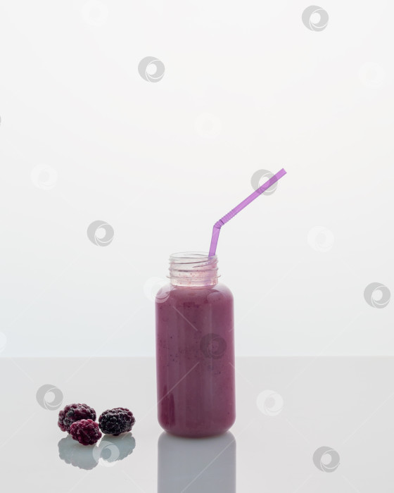 Скачать Пластиковая бутылка со смузи из ягодного йогурта, соломкой и замороженной черникой фотосток Ozero
