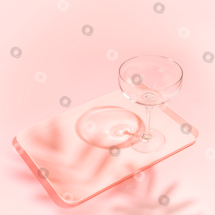 Скачать Пустой бокал для коктейля на подносе на розовом фоне фотосток Ozero