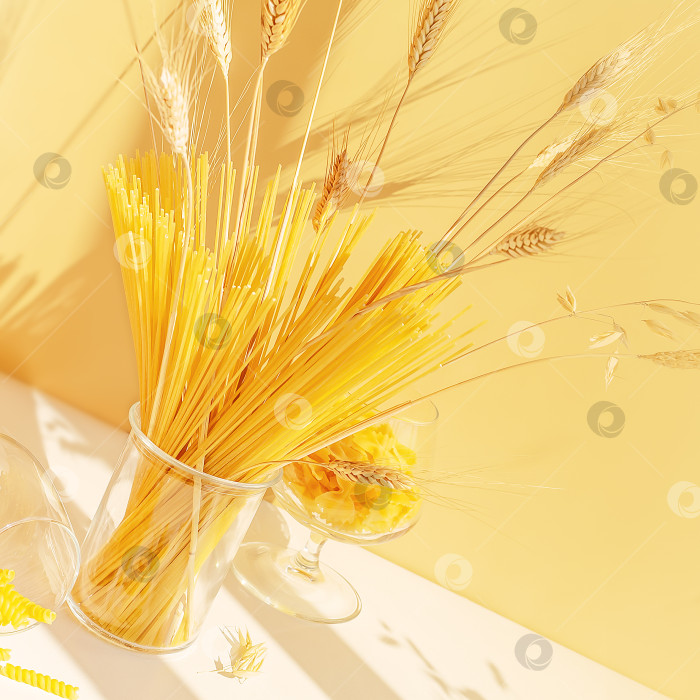 Скачать Сырые спагетти, фарфалле и паста жирандоле в бокалах на белом столе фотосток Ozero