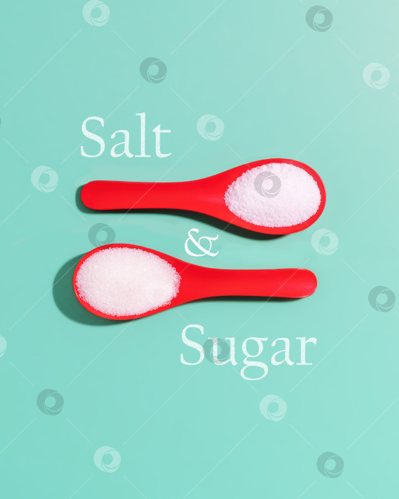 Скачать Красные пластиковые ложки с морской солью и сахаром и надписью sugar and salt на синем фоне фотосток Ozero