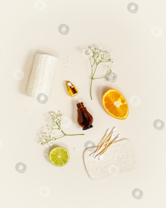 Скачать Экологически чистая спа-композиция с бутылочкой сыворотки, апельсином, лаймом и банными принадлежностями фотосток Ozero