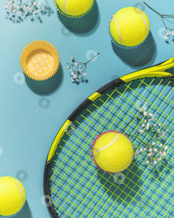 Скачать Желтые теннисные мячи и ракетка на синем фоне жесткого теннисного корта фотосток Ozero