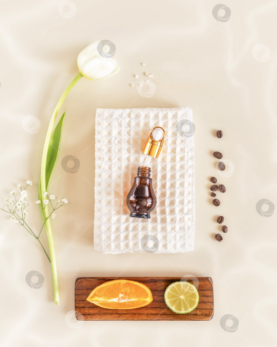 Скачать Экологически чистая косметическая композиция с белым полотенцем, бутылочкой сыворотки, апельсином, лаймом и тилипом фотосток Ozero