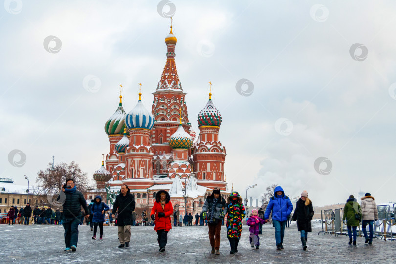 Скачать Москва, Россия, декабрь 2018 года. Туристы перед собором Василия Блаженного на Красной площади на фоне зимнего пасмурного неба (редакционная статья) фотосток Ozero