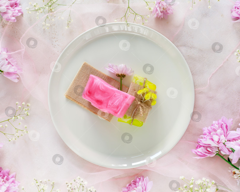 Скачать Два куска натурального цветочного домашнего мыла на белой тарелке на розовом фоне фотосток Ozero