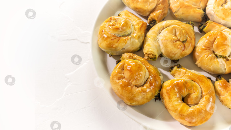 Скачать Национальное греческое блюдо с домашними пирогами с сыром фета и шпинатом на белом фоне фотосток Ozero