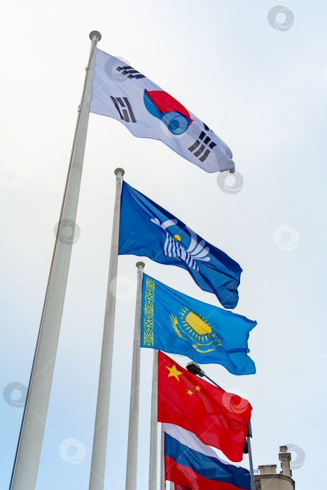 Вид на флаги Китая, Казахстана, Южной Кореи, России и Содружества  Независимых Государств на фоне облачного неба - Ozero - российский фотосток