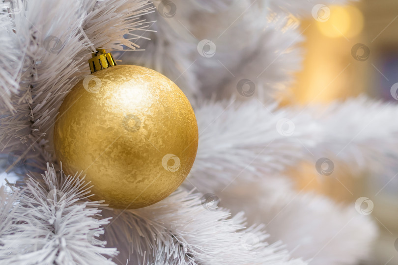Скачать Крупный план заснеженной искусственной рождественской елки, украшенной золотыми шарами фотосток Ozero