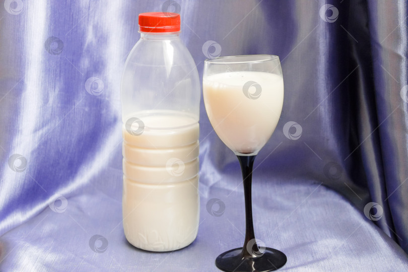 Скачать Бутылка и стакан молока на синем фоне. фотосток Ozero