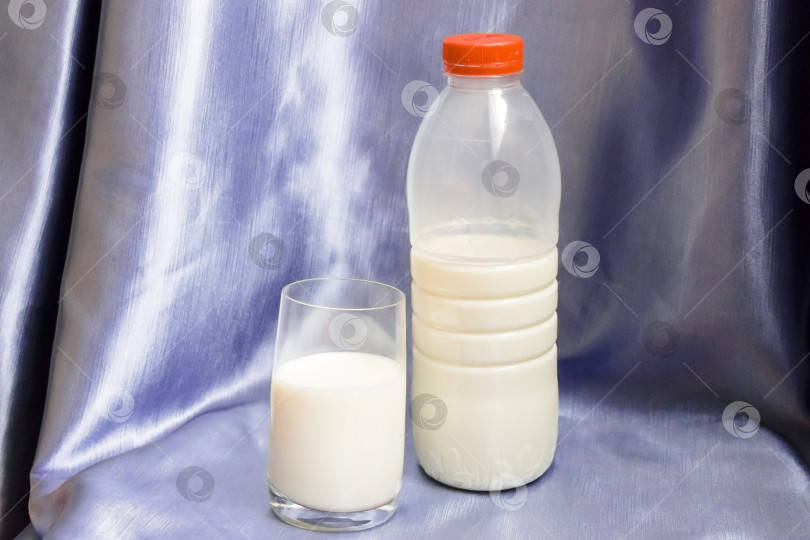 Скачать Бутылка и стакан молока на синем фоне. фотосток Ozero