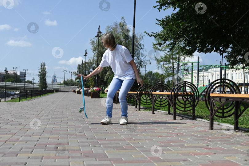 Скачать Активная женщина средних лет катается на скейтборде по пустой дороге или шоссе. Обычная городская женщина, отдыхающая на скейтборде после работы. Концепция современного образа жизни фотосток Ozero