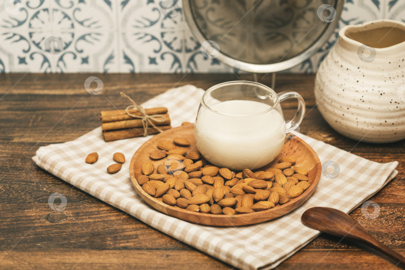 Скачать Чашка миндального молока с миндальными орехами на деревянной тарелке фотосток Ozero