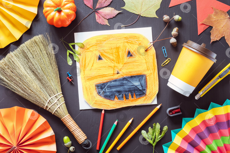 Скачать Осенняя плоская обложка с детским рисунком тыквы на Хэллоуин, цветными карандашами и осенними украшениями на черной классной доске фотосток Ozero