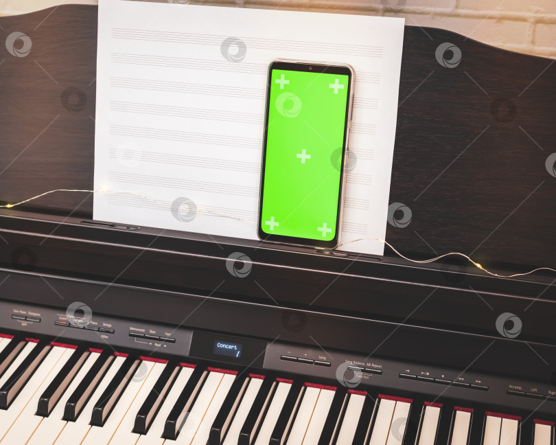 Скачать Смартфон с зеленым экраном на электронном пианино фотосток Ozero