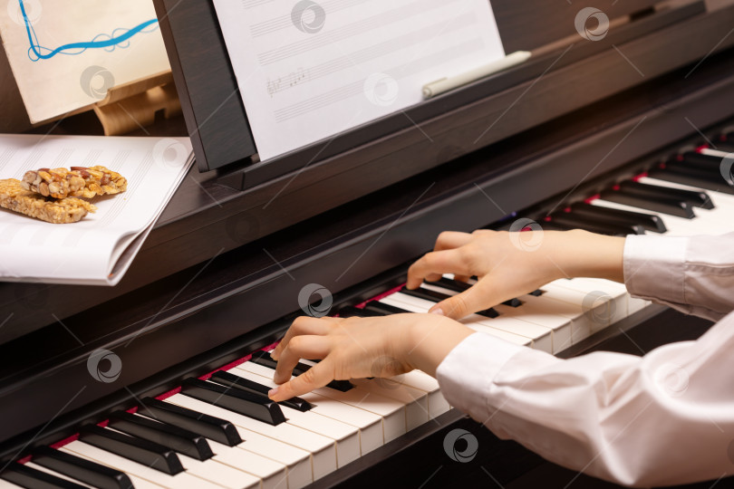 Скачать Мальчик играет на электронном пианино с батончиками мюсли фотосток Ozero