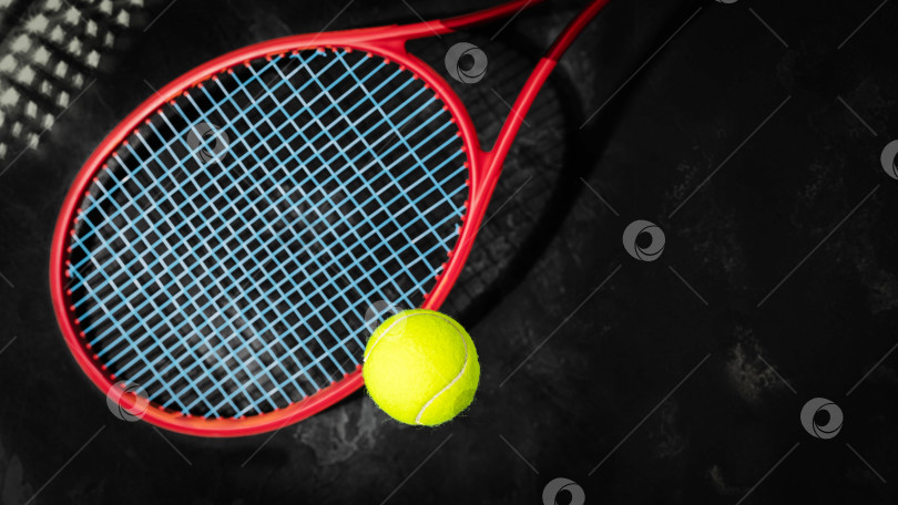 Скачать Желтый теннисный мяч с красной ракеткой на черном фоне с пробелом для копирования фотосток Ozero