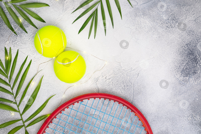 Скачать Теннисные мячи с ракеткой и пальмовыми листьями на синем фоне фотосток Ozero