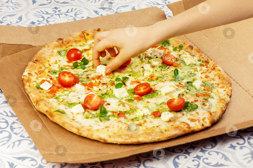Скачать Детская рука берет кусочек сыра из пиццы фотосток Ozero