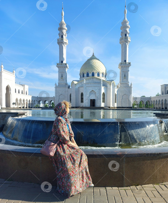 Скачать Турист с аудиогидом на фоне Белой мечети в Болгар,Татарстан.Болгар,Россия,06.2023. фотосток Ozero