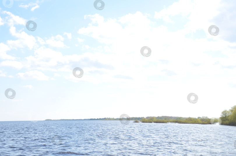 Скачать Озеро Ильмень у Великого Новгорода, весенний разлив, водная гладь и голубое облачное небо в облаками в солнечный день фотосток Ozero