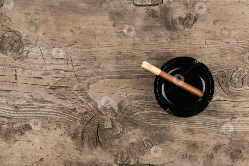 Скачать Стеклянная пепельница с подставками для сигар на деревянной поверхности фотосток Ozero