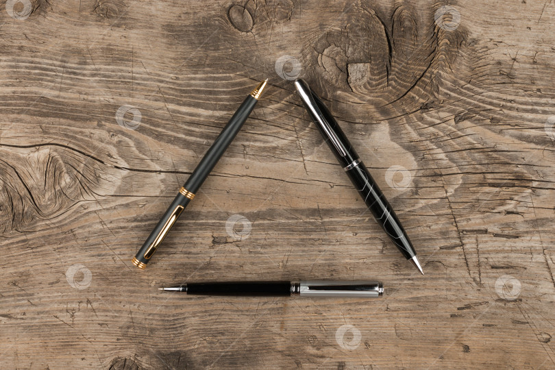 Скачать Черные, золотые и серебряные ручки с деревянной текстурой фотосток Ozero