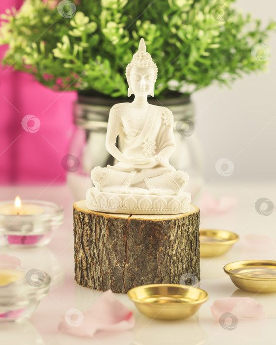 Скачать Статуя Будды на деревянном подиуме, лепестки роз и свечи фотосток Ozero