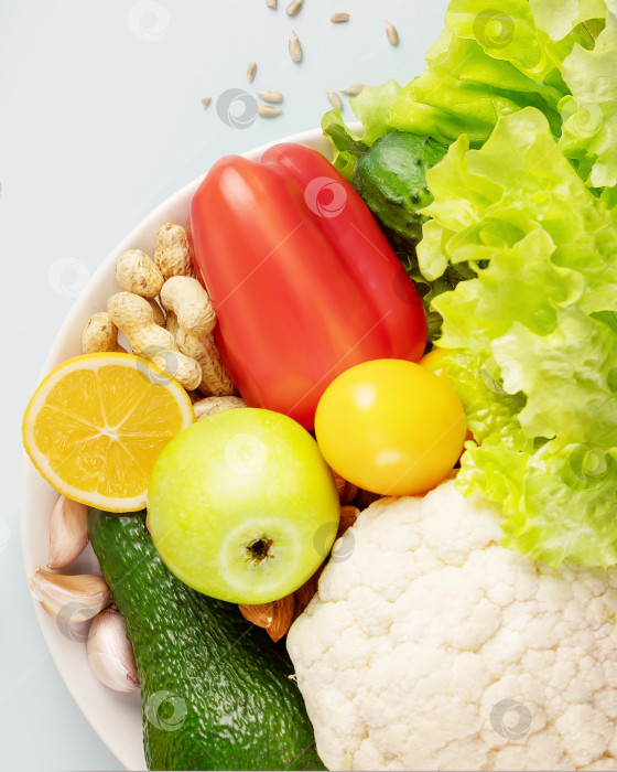 Скачать Органические овощи и фрукты, орехи, семечки на белой тарелке фотосток Ozero
