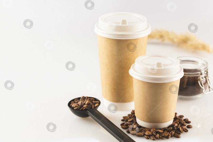 Скачать Две одноразовые экологически чистые чашки и молотый кофе в стеклянной банке фотосток Ozero