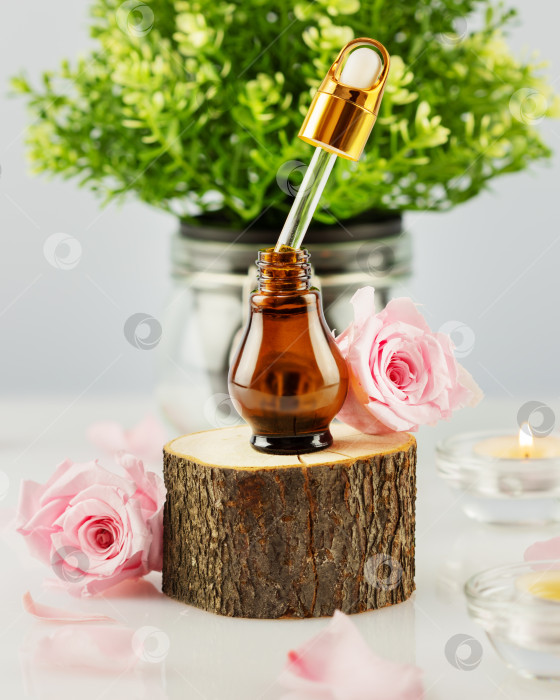 Скачать Органическая розовая сыворотка на деревянном подиуме, лепестки роз и свечи фотосток Ozero