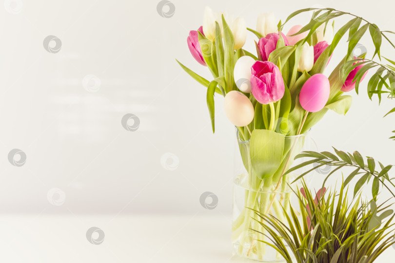 Скачать Тюльпаны и декоративные яйца в стеклянной банке на нейтральном сером фоне фотосток Ozero
