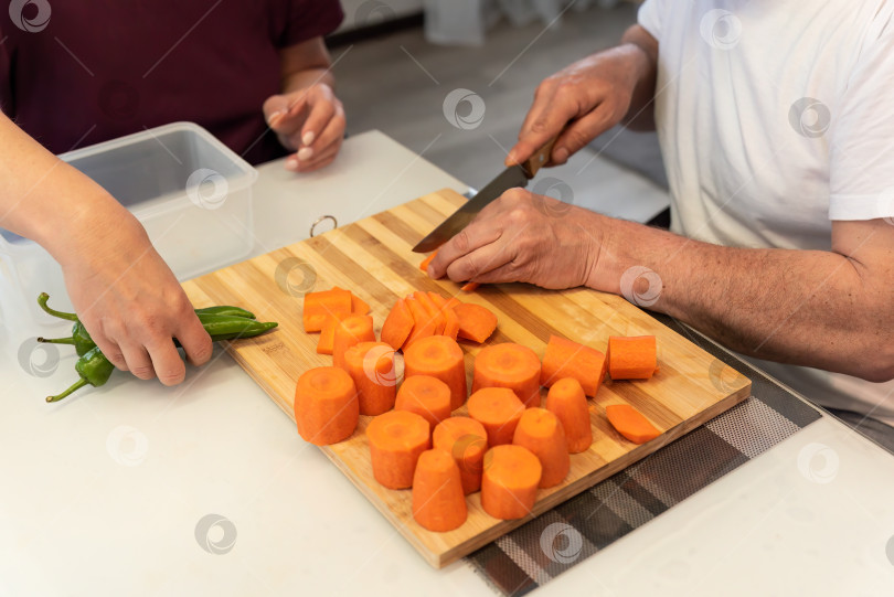 Скачать Мужчина и женщина готовят вместе, режут овощи для вегетарианского ужина фотосток Ozero