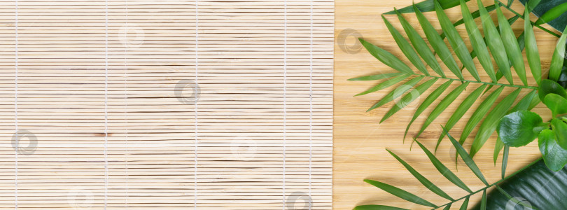 Скачать Пустая деревянная доска с натуральным ковриком и тропическими листьями фотосток Ozero