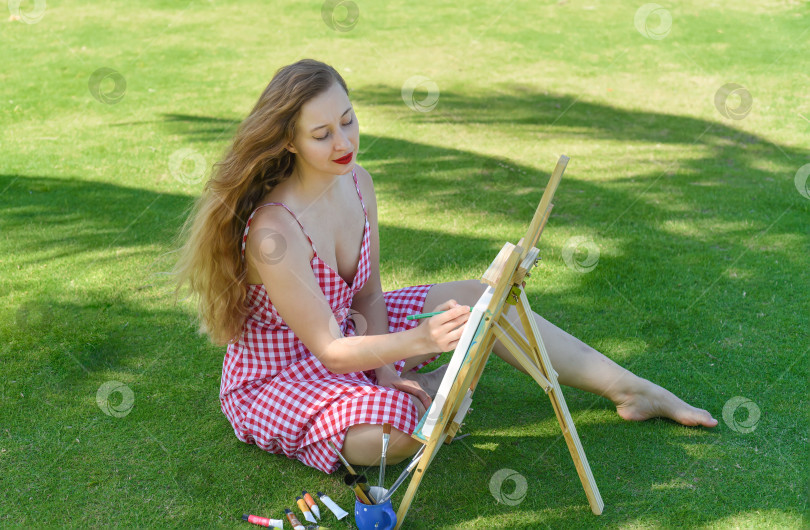 Скачать Молодая художница держит в руках банку с кистями и мольберт на фоне моря и пальм летом фотосток Ozero