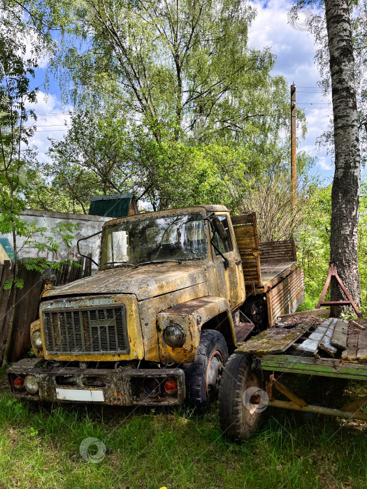 Скачать Старый ржавый грузовик на траве около забора. фотосток Ozero