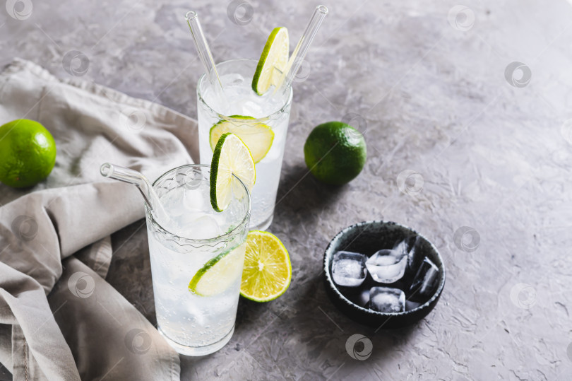 Скачать Алкогольный коктейль мохито с лаймом и льдом в бокалах на столе фотосток Ozero