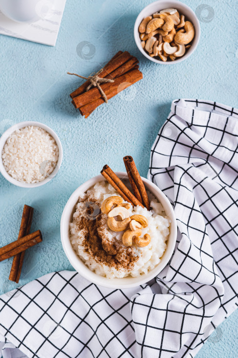 Скачать Миска с вкуснейшим рисовым пудингом с корицей и орехами на столешнице в вертикальном положении фотосток Ozero