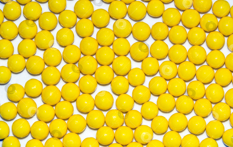 Скачать Множество желтых круглых драже с аскорбиновой кислотой и витамином С, выделенных на белом фоне фотосток Ozero