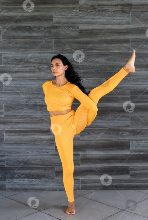 Скачать Райская птица или Сварга Двиджасана йога с украинской женщиной, выполняющей ее в помещении фотосток Ozero
