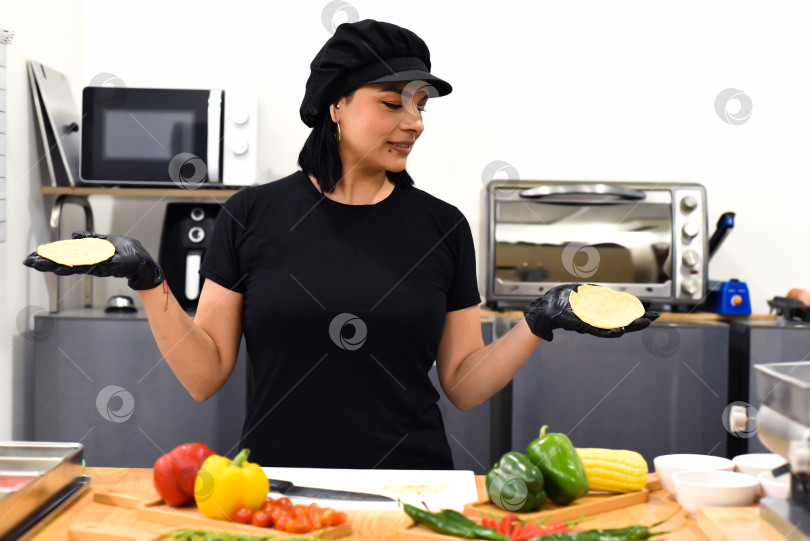 Скачать Мексиканка показывает тако во время приготовления на кухне фотосток Ozero