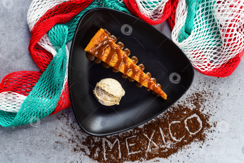 Скачать Кукурузный пирог Тлателолко с кофейным кремом на черной тарелке и мексиканским декором фотосток Ozero