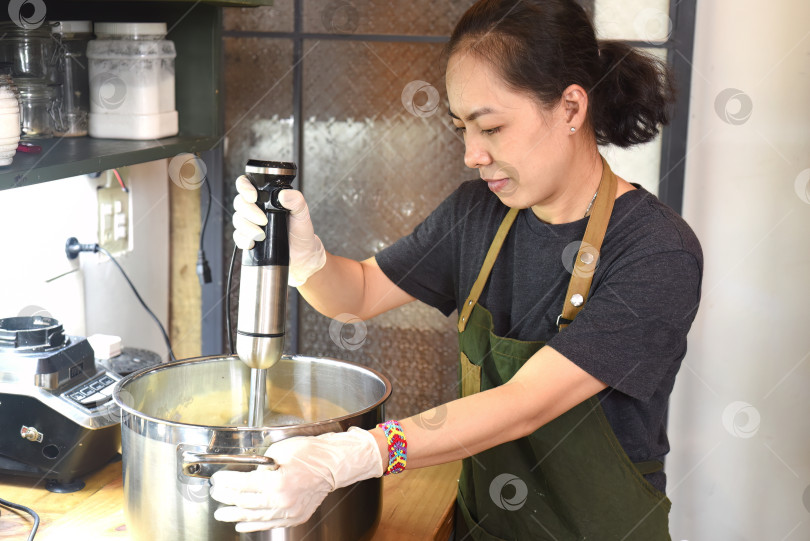 Скачать Молодая вьетнамка размешивает основу для мороженого с авокадо фотосток Ozero