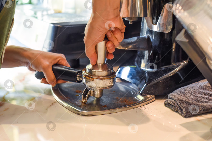 Скачать Руки, отжимающие кофейные зерна для кофемашины крупным планом фотосток Ozero