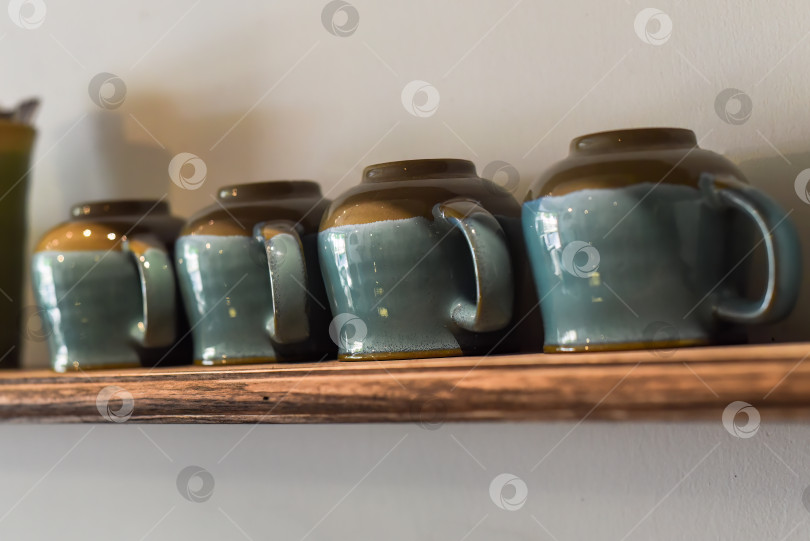 Скачать Множество синих чашек в ряд на деревянной полке на кухне фотосток Ozero